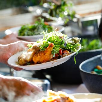 Hands serving salad